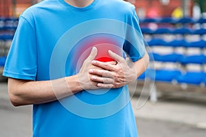 Heart attack, man with chest pain after workout on a sports ground