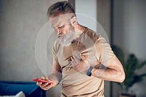 A midaged bearded man having a heart attack