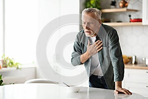 Heart Attack. Senior man suffering from chest pain at home
