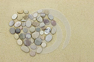 Heart of beach stones on a sandy beach