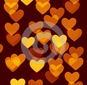 Heart bokeh background, photo blurry objects, yellow on dark brown