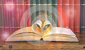 Heart and book. A open book with pages forming the heart, rank of books.