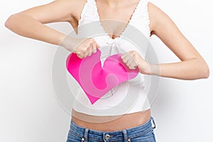 Heart-broken woman tearing paper heart