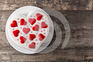 Heart cake for St. Valentine`s Day, Mother`s Day, or Birthday, decorated with sugar hearts on wooden table
