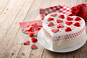 Heart cake for St. Valentine`s Day, Mother`s Day, or Birthday, decorated with sugar hearts on wooden table. Copy space