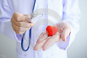 Heart check Doctor holding Red heart on hands at hospital office.Healthcare And Medical concept