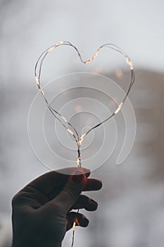 Heart from Christmas lights on rustic background