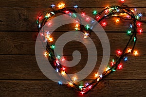 Heart from christmas lights on wood background