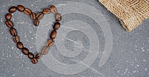 Heart from coffee beans with burlap at grey kitchen worktop background photo