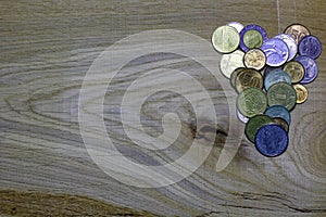 Heart of coins on wooden background.