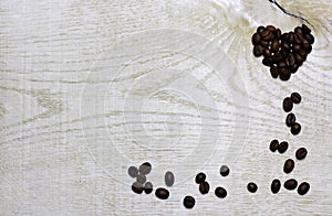 Heart and corner frame border of coffee beans on light wooden background.