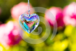 heart crystal glass refract sunlight - rose garden background