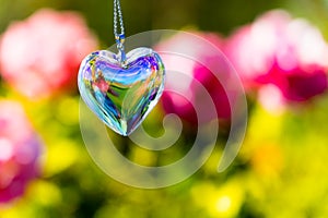 Heart crystal glass refract sunlight - rose garden background