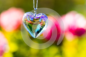 Heart crystal glass refract sunlight - rose garden background