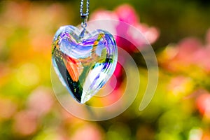 Heart crystal glass refract sunlight - rose garden background