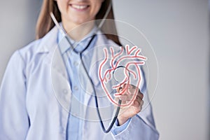 Heart diagram, stethoscope and cardiology help of a woman doctor in a hospital with a smile. Health, wellness and