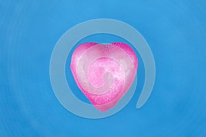 Heart dipped in pink paint on blue textured background