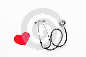 Heart disease concept. Stethoscope near heart sign on white background top view