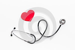 Heart disease concept. Stethoscope near heart sign on white background top view