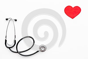 Heart disease concept. Stethoscope near heart sign on white background top view copy space