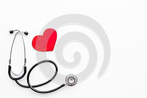 Heart disease concept. Stethoscope near heart sign on white background top view copy space
