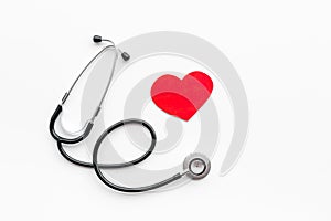 Heart disease concept. Stethoscope near heart sign on white background top view copy space