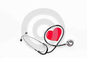 Heart disease concept. Stethoscope near heart sign on white background top view copy space