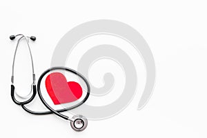 Heart disease concept. Stethoscope near heart sign on white background top view copy space