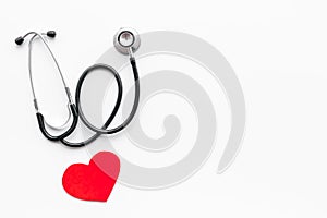 Heart disease concept. Stethoscope near heart sign on white background top view copy space