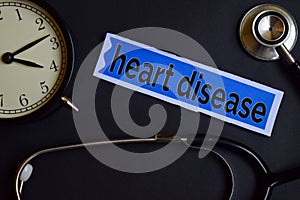 Heart Disease on the print paper with Healthcare Concept Inspiration. alarm clock, Black stethoscope.