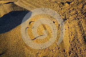 Heart drawn on the beach during sunset