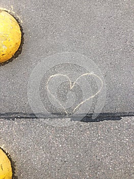 A heart drawn in chalk on the asphalt