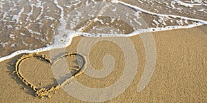 Heart drawn on ocean beach sand. Romantic.