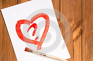 The heart drawn with red paint on a clean sheet of paper with a