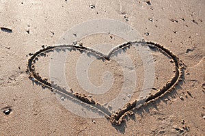 Heart drawn in the sand on the beach