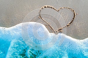 Heart drawn on a sand of beach