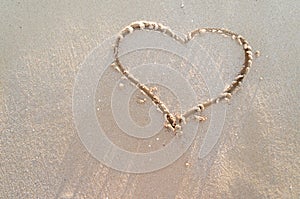 Heart drawn on a sand of beach