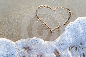 Heart drawn on a sand of beach