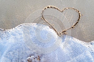 Heart drawn on a sand of beach