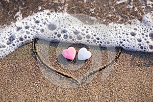 Heart drawn in the sand with two hearts