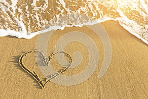 Heart drawn in sea beach sand, soft wave in a Sunny summer day. Love.