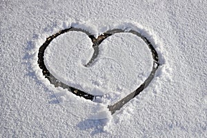 Heart drawn on white clear thin snow