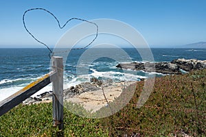 Heart in the fence wire above the ocean