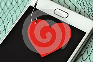 Heart on fish hook on mobile phone and fishing net - Love concept