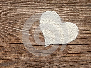 Heart of flour on old wooden board