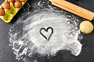 Heart on flour, rolling pin, eggs and dough
