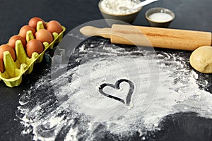 Heart on flour, rolling pin, eggs and dough