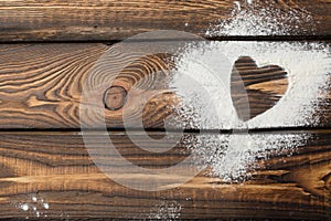 Heart free space. Heart made of flour on a wooden background