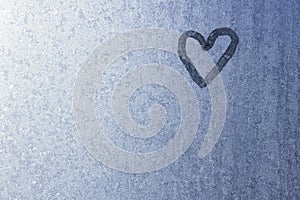 Heart on frozen glass. Ice on a window background. Small