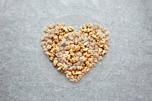 Heart from granola on parchment paper, top view. Muesli, concept healthy breakfast